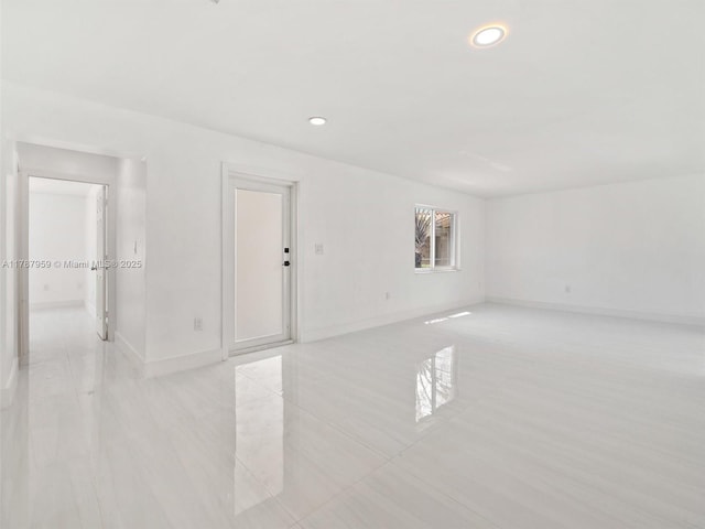 unfurnished room featuring recessed lighting and baseboards