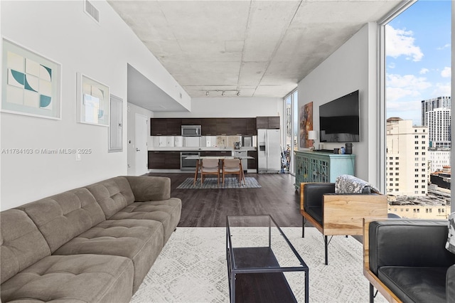 living area with dark wood-style floors and visible vents