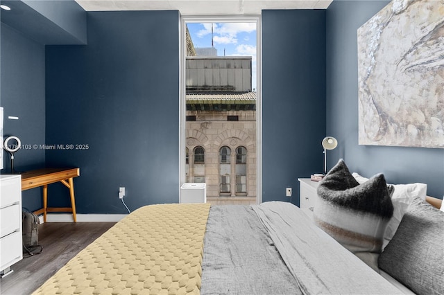 bedroom with dark wood-style floors and baseboards