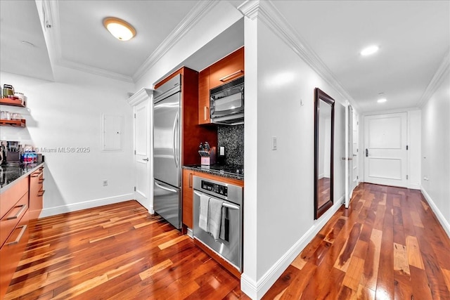 kitchen featuring baseboards, ornamental molding, black appliances, and wood-type flooring
