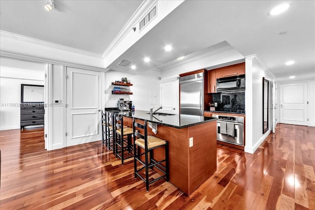 1830 S Ocean Dr Unit Lph4910, Hallandale Beach, FL 33009 - kitchen featuring stainless steel appliances, ornamental molding, a kitchen breakfast bar, hardwood / wood-style floors, and recessed lighting