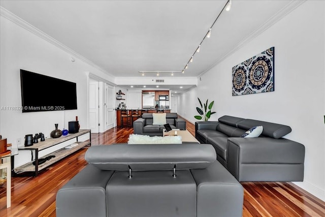 living area with track lighting, wood finished floors, and crown molding