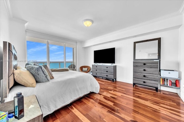 bedroom with wood finished floors, baseboards, and ornamental molding