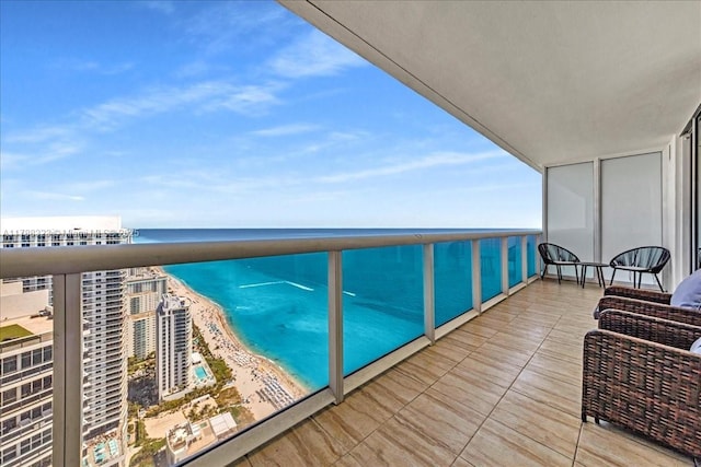 balcony featuring a beach view and a water view