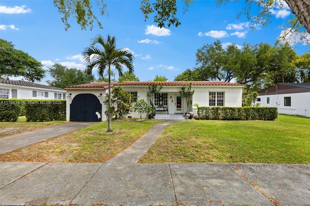 55 NE 87th St, El Portal, FL 33138 - mediterranean / spanish home with aphalt driveway, stucco siding, a tiled roof, and a front yard