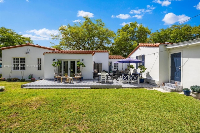 55 NE 87th St, El Portal, FL 33138 - rear view of property featuring french doors, a yard, a patio area, and a tile roof