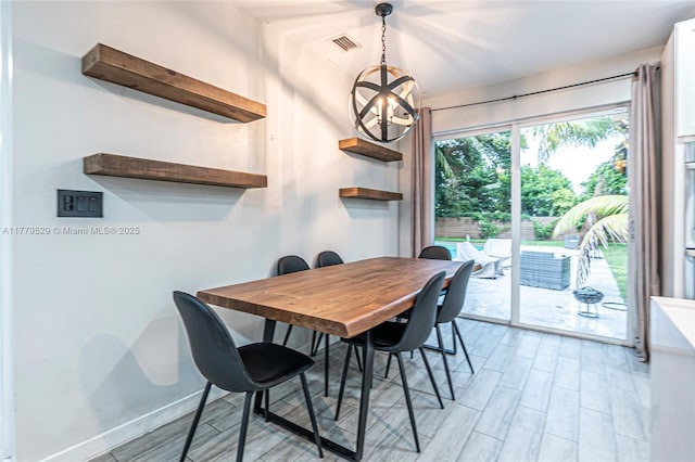 dining room featuring visible vents, baseboards, a chandelier, and light wood-style floors
