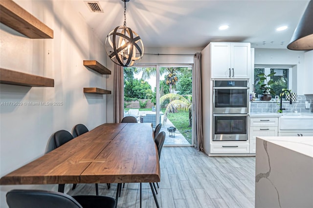 dining space featuring a notable chandelier, recessed lighting, visible vents, and light wood-style flooring