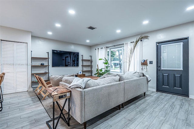 living room featuring light wood finished floors, recessed lighting, and visible vents