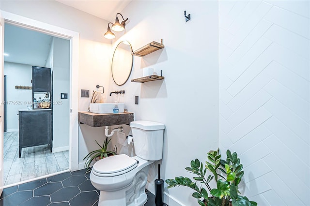 bathroom with toilet, tile patterned flooring, and baseboards