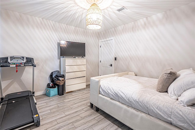 bedroom with a notable chandelier, visible vents, baseboards, and light wood-style floors