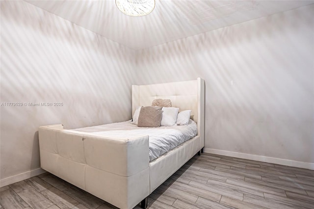 bedroom featuring baseboards and wood finished floors