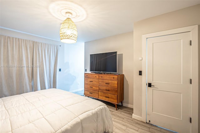 bedroom featuring baseboards and light wood finished floors