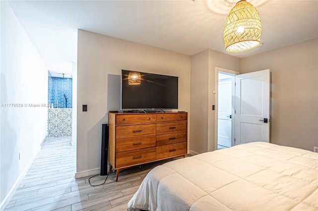 bedroom with light wood finished floors, access to exterior, and baseboards