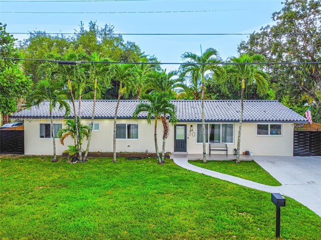 ranch-style house with a front lawn, stucco siding, a tile roof, and concrete driveway