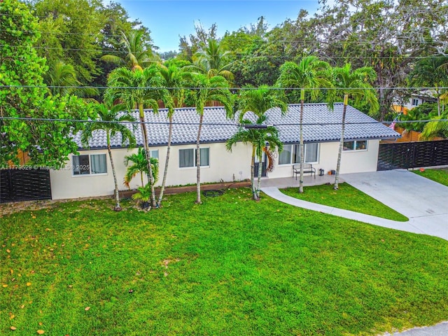 ranch-style home featuring fence, a front lawn, driveway, and stucco siding
