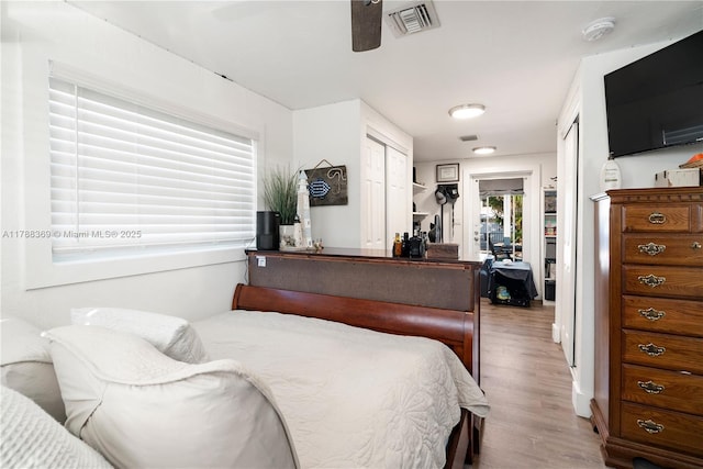 bedroom featuring ceiling fan, light wood-style floors, and visible vents