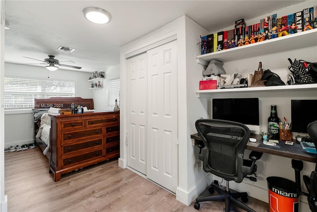 office area with baseboards, a ceiling fan, visible vents, and light wood finished floors