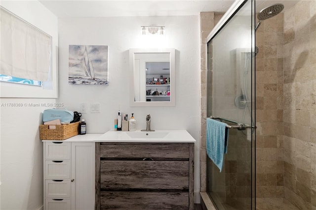 bathroom with a shower stall and vanity