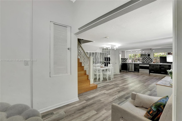 3375 SW 29th Ter, Miami, FL 33133 - living area featuring stairway, light wood-style flooring, and a chandelier