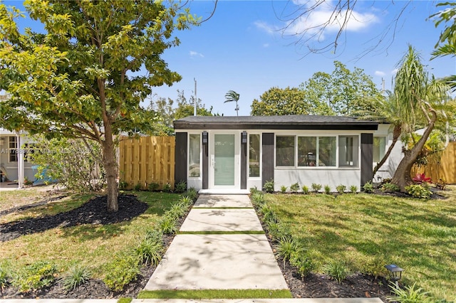 view of front of property with fence and a front lawn