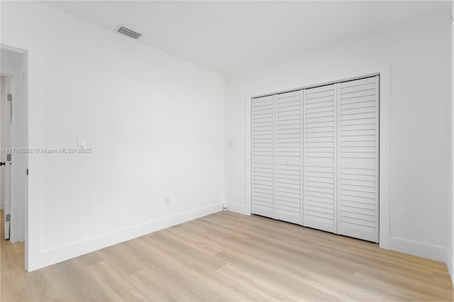 unfurnished bedroom with light wood-style floors, visible vents, and baseboards
