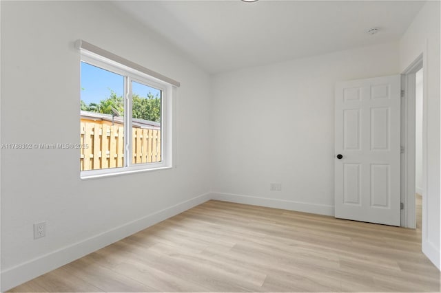 empty room with baseboards and light wood-style floors