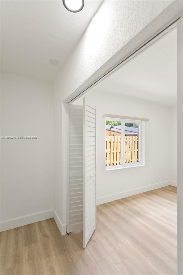 interior space featuring light wood-type flooring and baseboards
