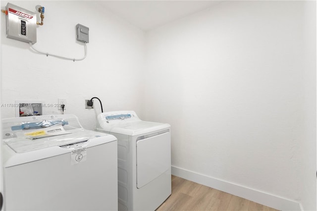 washroom with washing machine and clothes dryer, light wood-style floors, laundry area, and baseboards