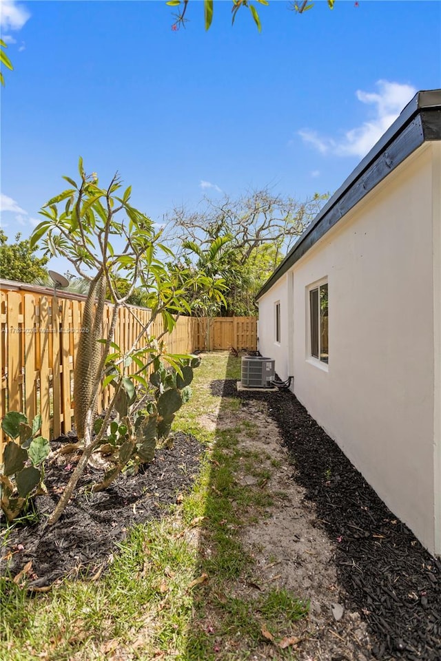 view of yard with a fenced backyard and central AC unit