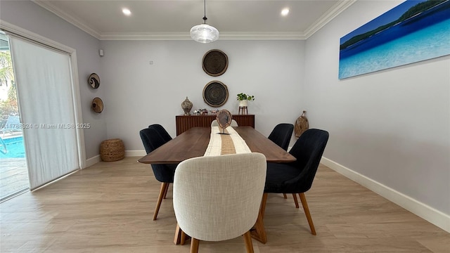 dining room with light wood-style flooring, crown molding, and baseboards