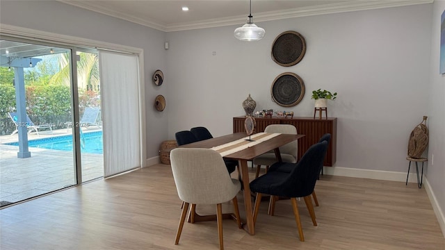 dining space with light wood-type flooring, baseboards, and ornamental molding