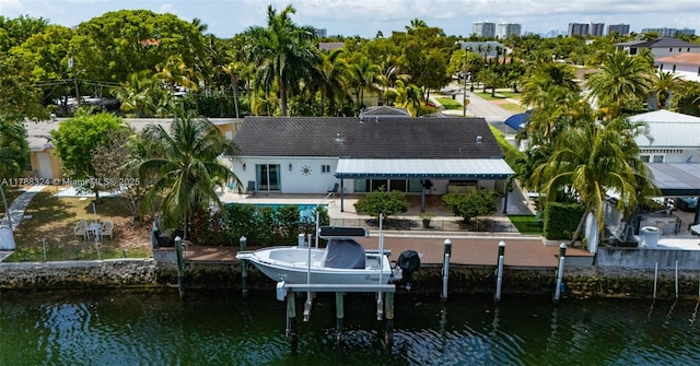 2105 Arch Creek Dr, North Miami, FL 33181 - rear view of house with boat lift, a water view, a patio, and view of wooded area