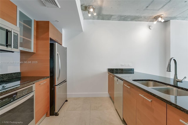 3451 NE 1st Ave Unit M0808, Miami, FL 33137 - kitchen featuring dark stone counters, modern cabinets, a sink, brown cabinetry, and appliances with stainless steel finishes