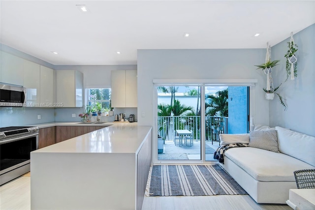 381 Franklin St, Hollywood, FL 33019 - kitchen with modern cabinets, a peninsula, stainless steel appliances, and light countertops