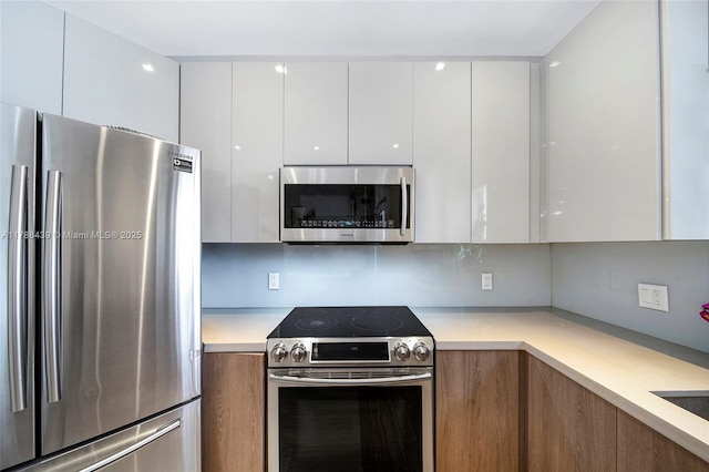 381 Franklin St, Hollywood, FL 33019 - kitchen featuring modern cabinets, light countertops, white cabinetry, and appliances with stainless steel finishes
