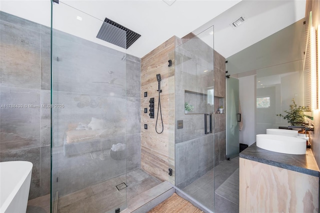 381 Franklin St, Hollywood, FL 33019 - bathroom featuring a soaking tub, a sink, double vanity, visible vents, and a shower stall