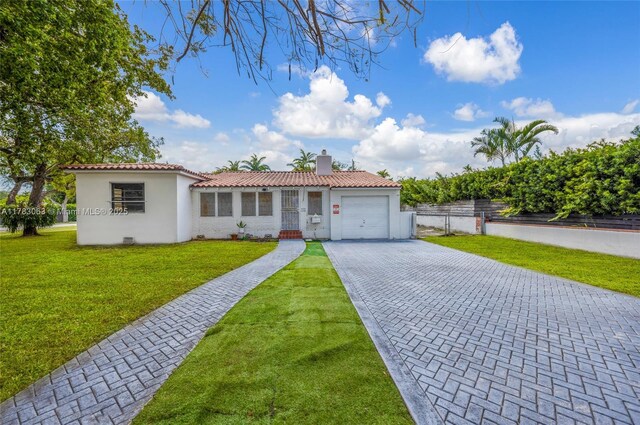 790 NE 96th St, Miami Shores, FL 33138 - mediterranean / spanish-style home featuring a tile roof, decorative driveway, a garage, fence, and a front yard