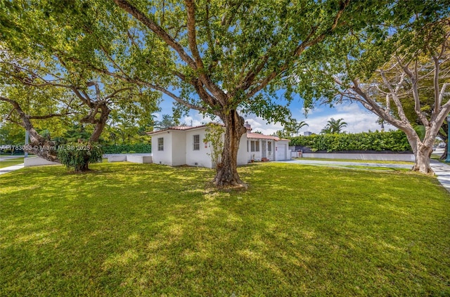 790 NE 96th St, Miami Shores, FL 33138 - view of front facade with stucco siding, an attached garage, and a front lawn