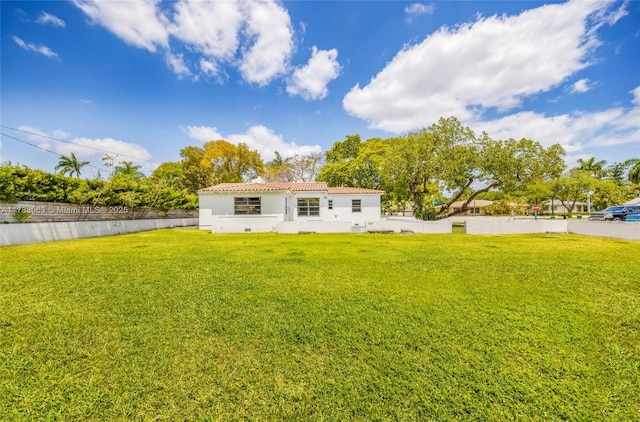 790 NE 96th St, Miami Shores, FL 33138 - back of house with a lawn, a tiled roof, stucco siding, and fence