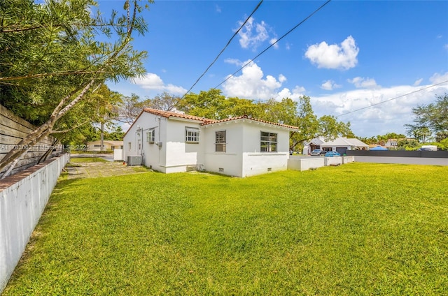 790 NE 96th St, Miami Shores, FL 33138 - rear view of house featuring a tiled roof, central air condition unit, fence, a lawn, and stucco siding