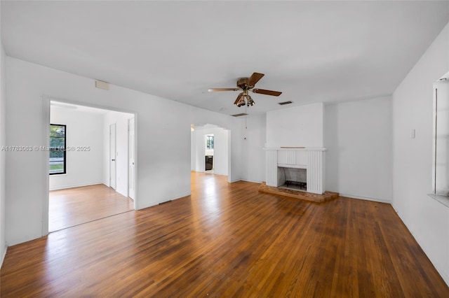 790 NE 96th St, Miami Shores, FL 33138 - unfurnished living room featuring ceiling fan, a healthy amount of sunlight, a brick fireplace, and wood finished floors
