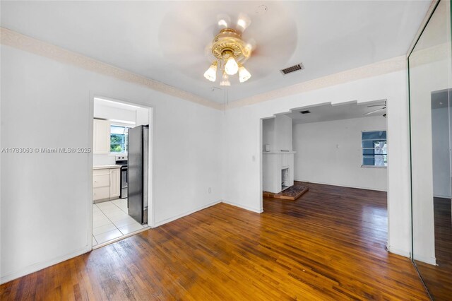 790 NE 96th St, Miami Shores, FL 33138 - interior space featuring a fireplace with raised hearth, visible vents, a ceiling fan, baseboards, and light wood-style flooring