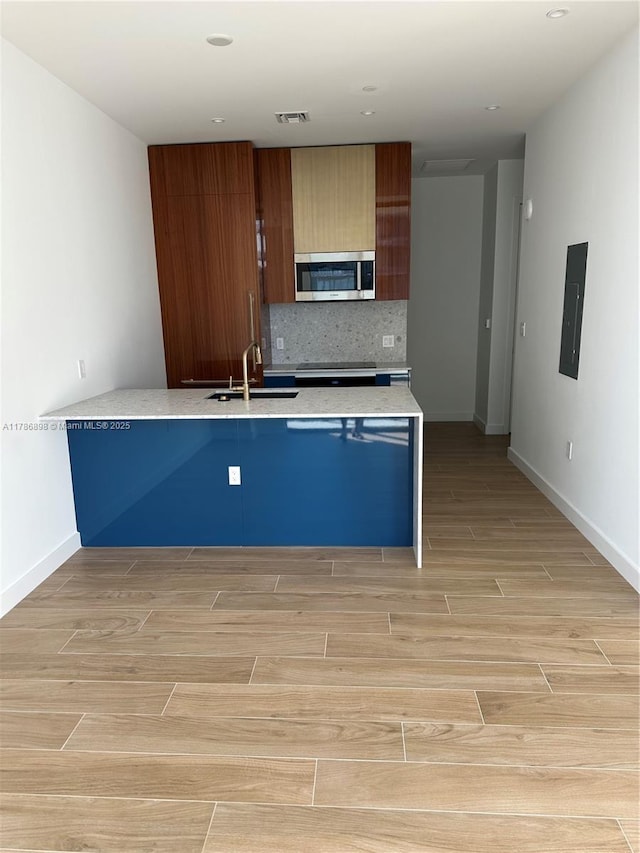 2655 S Bayshore Dr Unit 1607, Miami, FL 33133 - kitchen featuring a sink, light wood-style floors, a peninsula, stainless steel microwave, and visible vents
