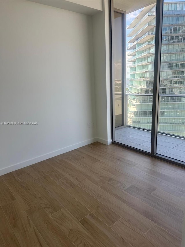 2655 S Bayshore Dr Unit 1607, Miami, FL 33133 - unfurnished room with baseboards, floor to ceiling windows, and wood finished floors