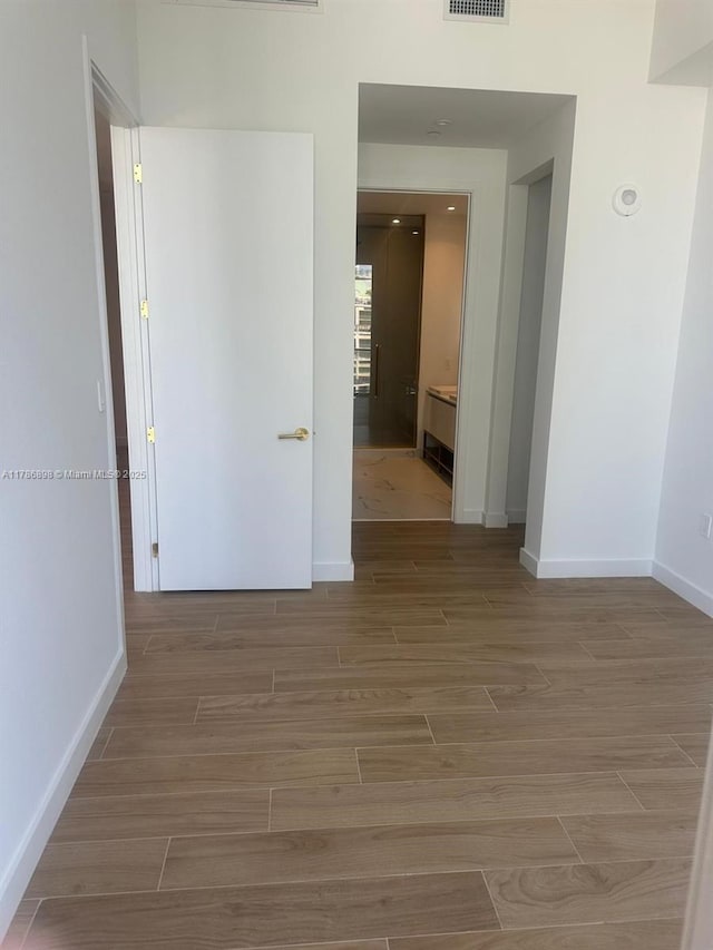 2655 S Bayshore Dr Unit 1607, Miami, FL 33133 - hallway with baseboards, visible vents, and wood finished floors