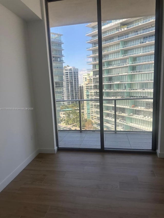 2655 S Bayshore Dr Unit 1607, Miami, FL 33133 - spare room with baseboards, a city view, and wood finished floors