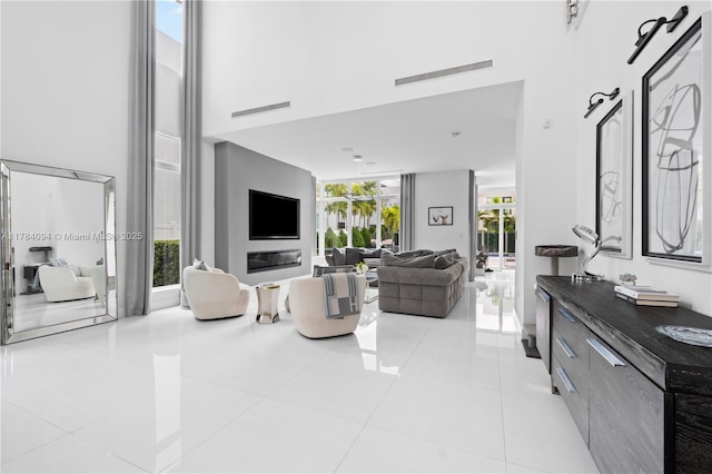 living room featuring a high ceiling, light tile patterned flooring, and visible vents