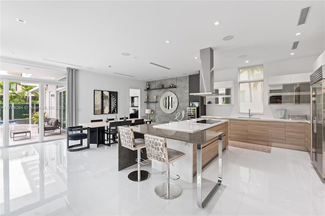 kitchen featuring modern cabinets, a healthy amount of sunlight, visible vents, and island exhaust hood