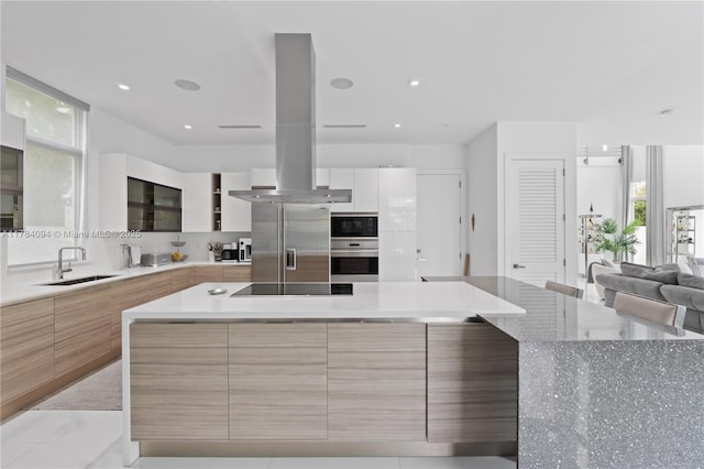 kitchen featuring island range hood, modern cabinets, a sink, and stainless steel appliances